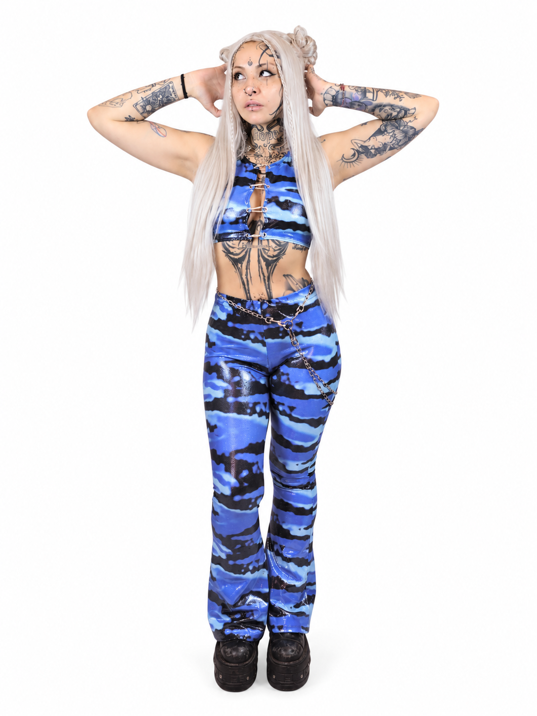 Glossy blue camouflage flared pants styled with a black crop top for an edgy techno clubwear look.