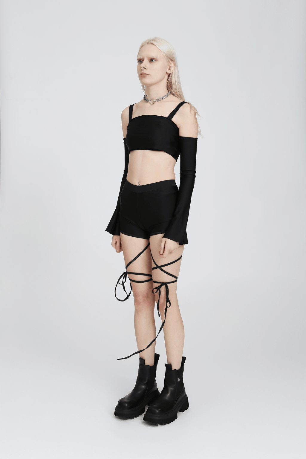 Black crop top with bell-shaped long sleeves and adjustable straps, fitted on a white background.