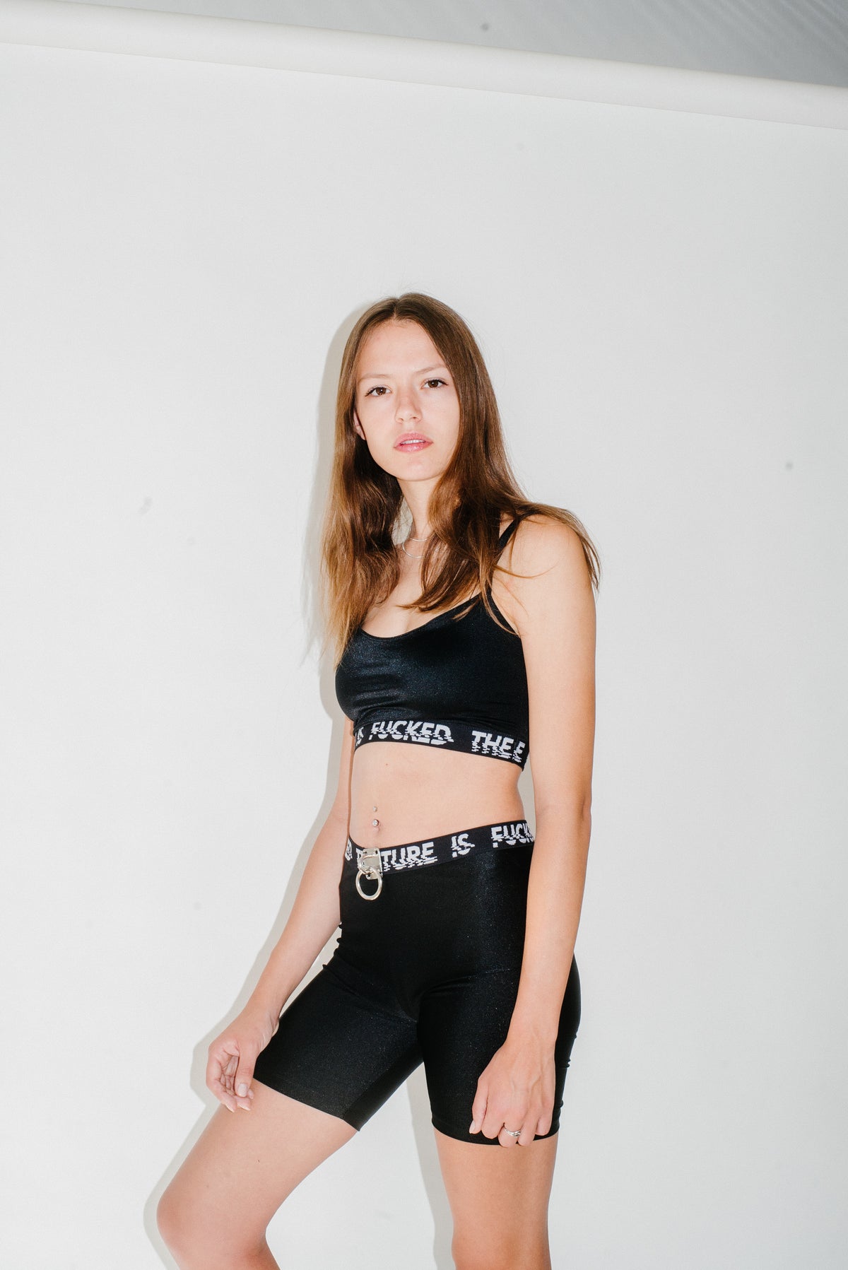 Black biker shorts with an "THE FUTURE IS FUCKED" elastic band and a silver hardware detail.