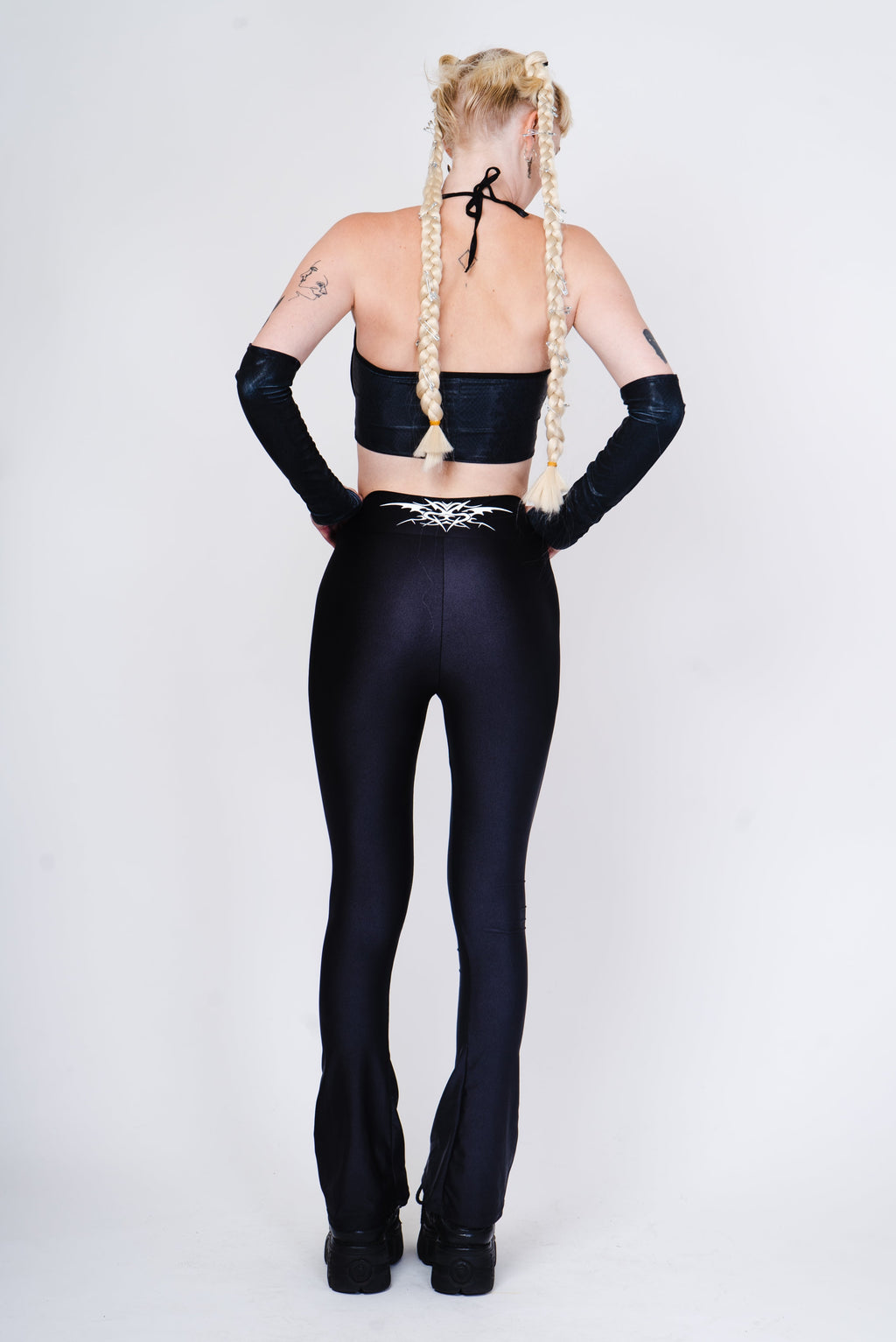 Black flared leggings with a tribal tattoo on the back in an alternative goth style.