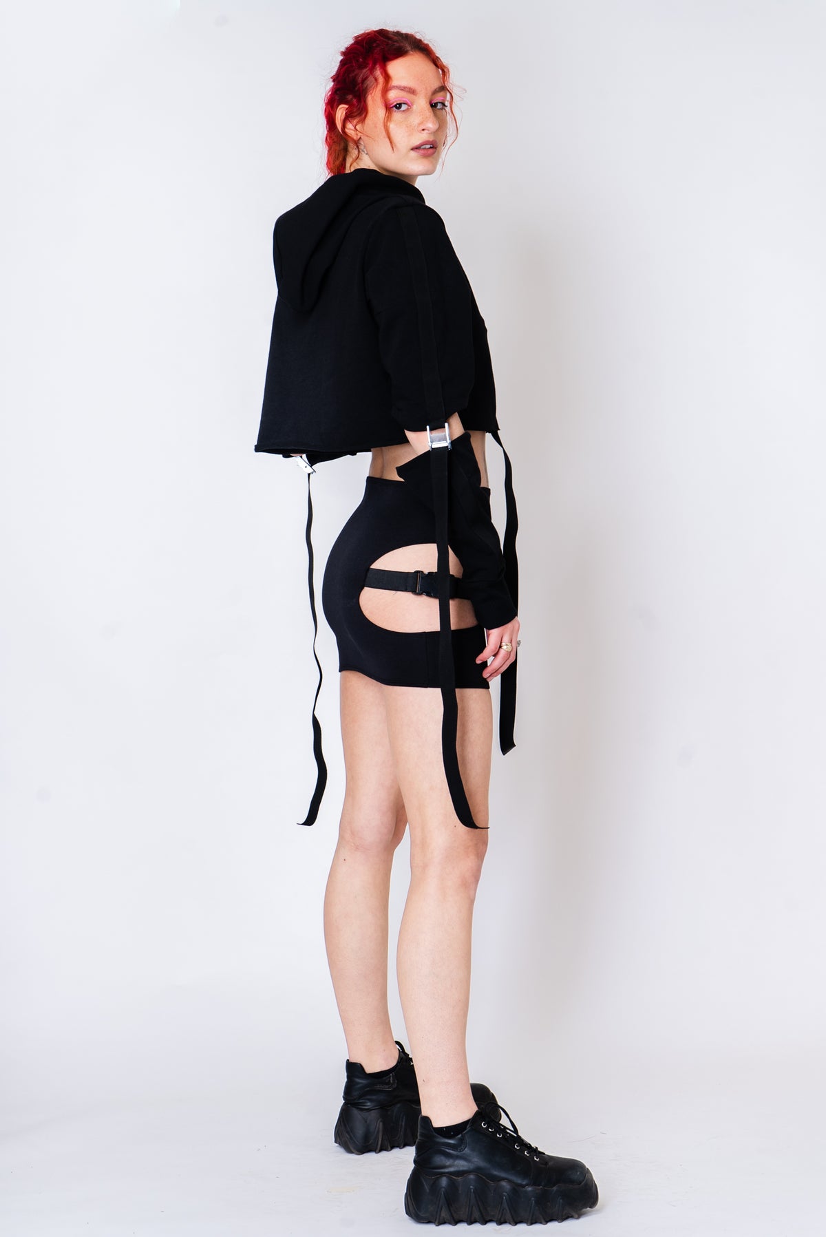 Black strappy hoodie with cutouts and silver hardware.