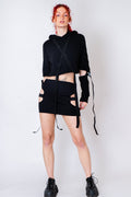 Black strappy hoodie with cutouts and silver hardware.