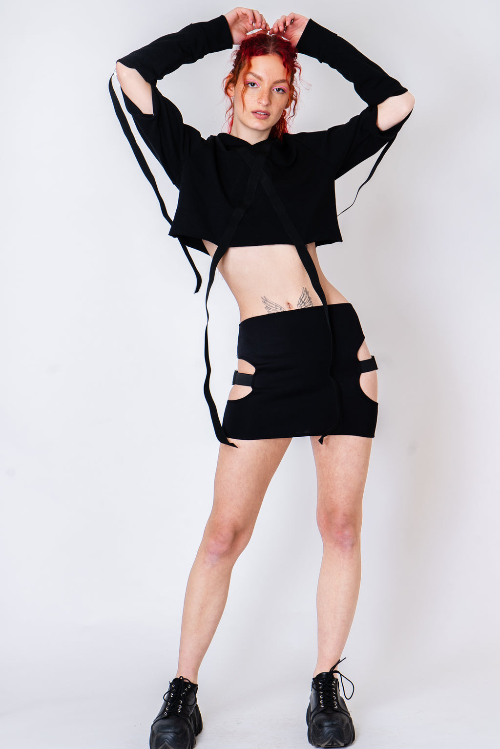 Black strappy hoodie with cutouts and silver hardware.