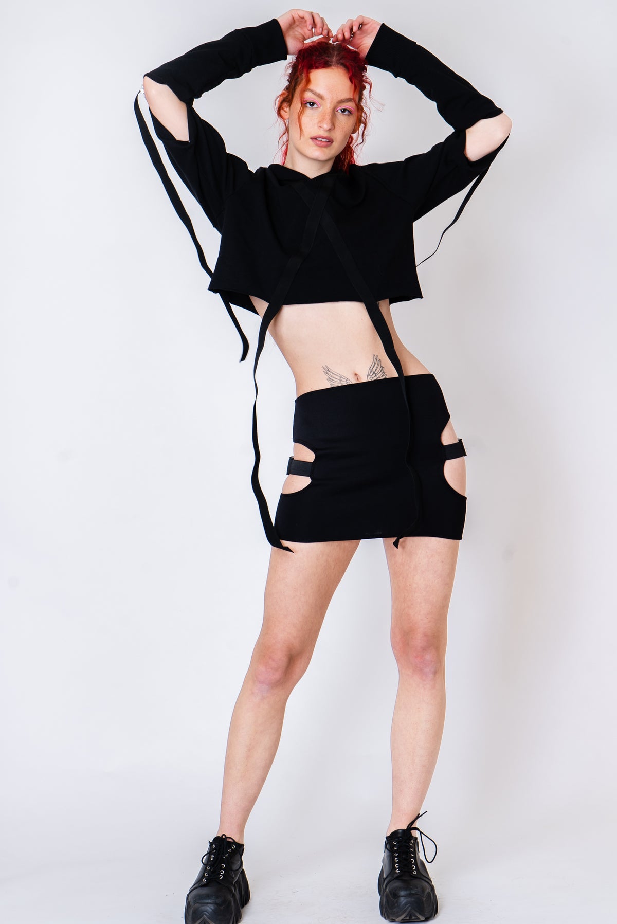 Black strappy hoodie with cutouts and silver hardware.